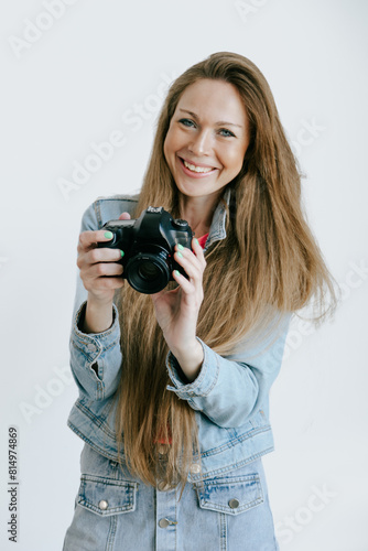 Smiling Woman Photographer with dslr Camera over studio plain background.