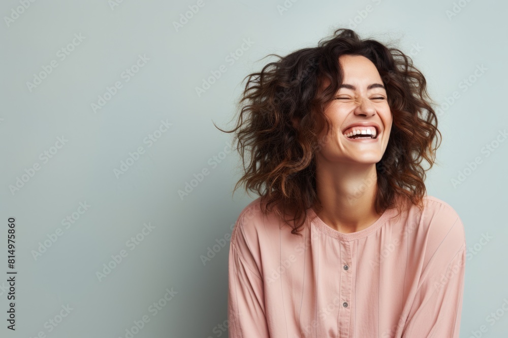 Portrait of a joyful woman in her 30s laughing isolated in pastel gray background Portrait of a joyful woman in her 30s laughing isolated in pastel gray background