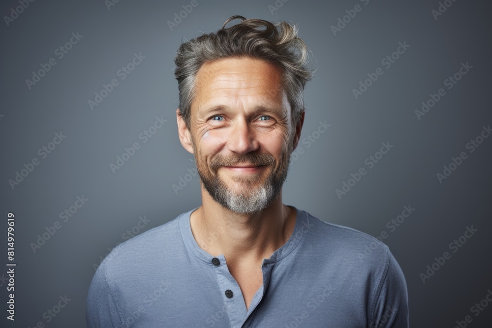 Portrait of a content man in his 40s smiling at the camera isolated on pastel gray background Portrait of a content man in his 40s smiling at the camera isolated on pastel gray background