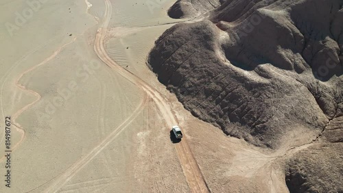 Aventura en 4x4 a través de paisaje montañoso árido desolado inhóspito en la Puna Argentina visto desde drone. photo