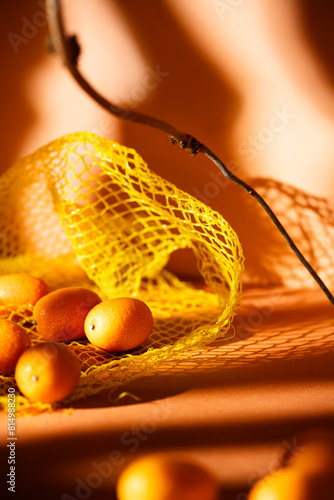 Kumquats spilled out of plastic net bag photo