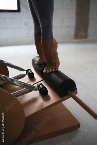 Detail of a woman's feet on a pilates chair.