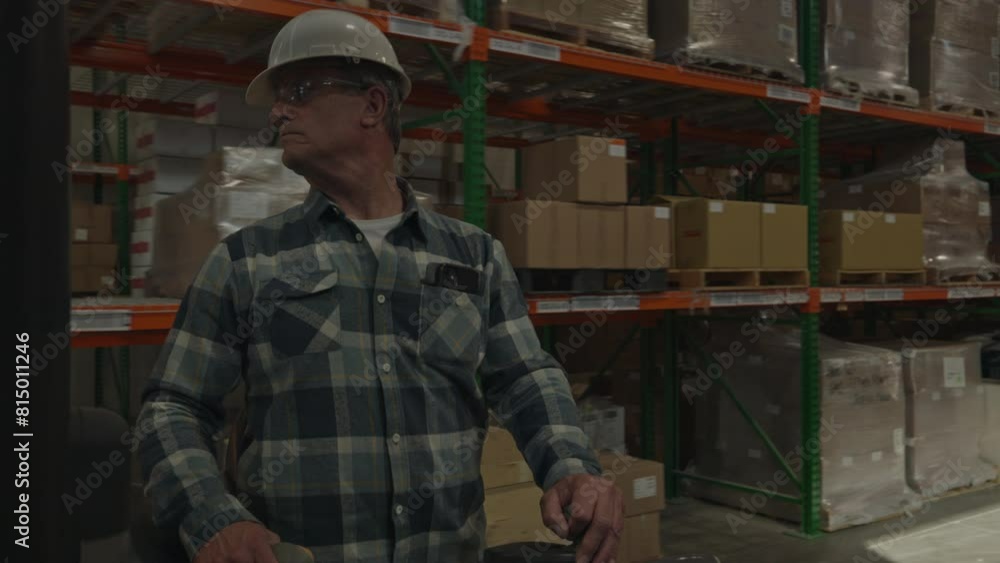 Tracking shot of worker driving forklift in warehouse / American Fork, Utah, United States Tracking shot of worker driving forklift in warehouse / American Fork, Utah, United States