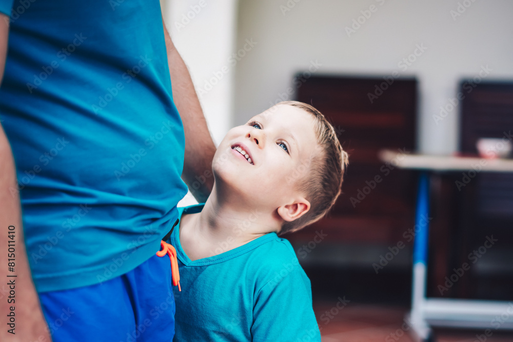 Closeup image of little son tender hugging his fathers hands, looking up on him. Happy childhood parenthood harmony Closeup image of little son tender hugging his fathers hands, looking up on him. Happy childhood parenthood harmony