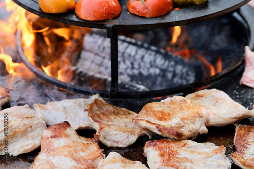 Raw fresh pieces of meat are placed on a cast iron grill to be grilled. © Silviu