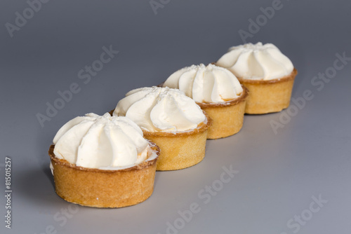 Small fruit tarts with custard top on a gray background © An-T