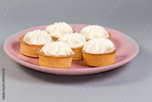 Small tarts with custard top on pink dish, side view © An-T