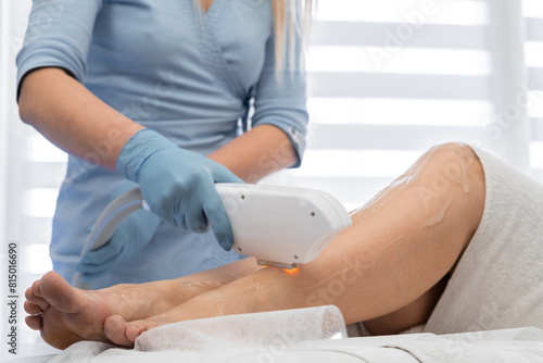 High-quality skin care, where an experienced cosmetologist performs photoepilation for smooth and attractive skin on the client's legs. Woman in the cosmetology office at the resort on vacation photo