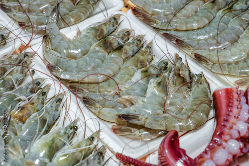 raw shrimp and octopus tentacles, seafood, street food, selective focus © elenvd