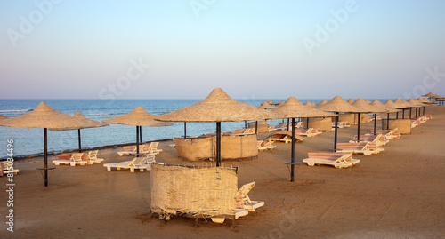 Beach with sun loungers and umbrellas at sunset, Marsa Alam region, Egypt.