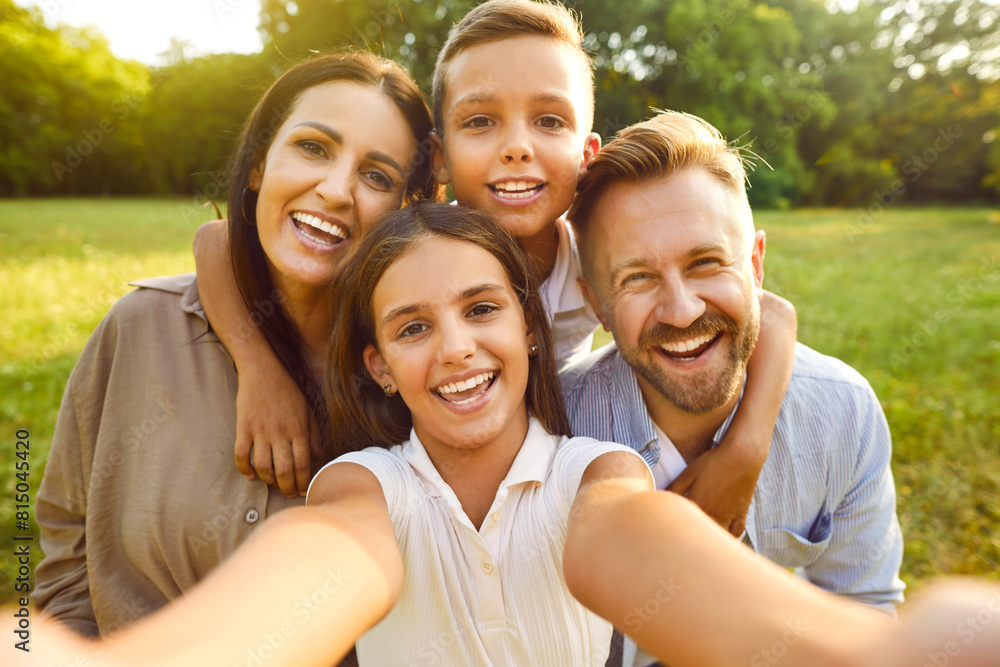 Selfie photo portrait of a happy family in nature. Beautiful joyful mother, father and children spending time together and relaxing in a fresh green summer park Selfie photo portrait of a happy family in nature. Beautiful joyful mother, father and children spending time together and relaxing in a fresh green summer park