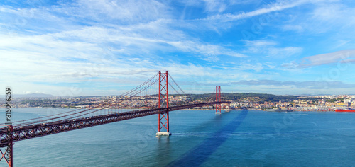 panoramic photo of the cityscape of Lisbon and the 25 April red bridge over the Tagus river on a sunny autumn day