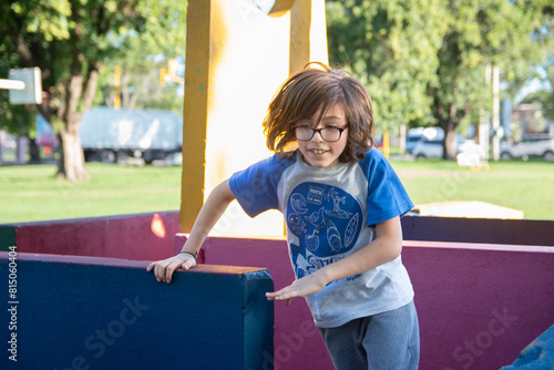 Niño con anteojos corriendo en parque infantil