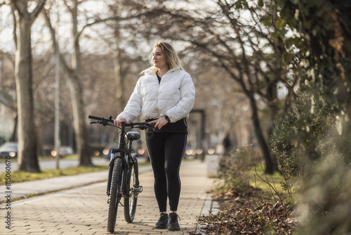 Woman Walking Bike Down Sidewalk © milanmarkovic78