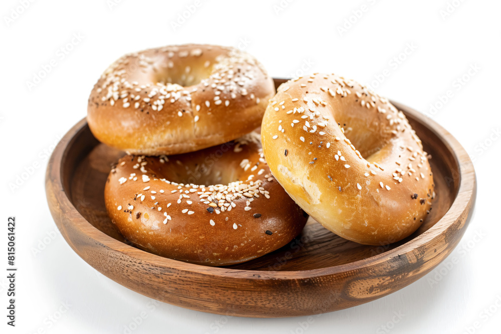 a wooden bowl filled with three bagels covered in sesame seeds a wooden bowl filled with three bagels covered in sesame seeds