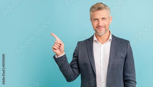 Happy young smiling professional business man wearing white shirt looking at camera pointing finger away at copy space showing aside presenting advertising offer standing isolated at light blue backgr