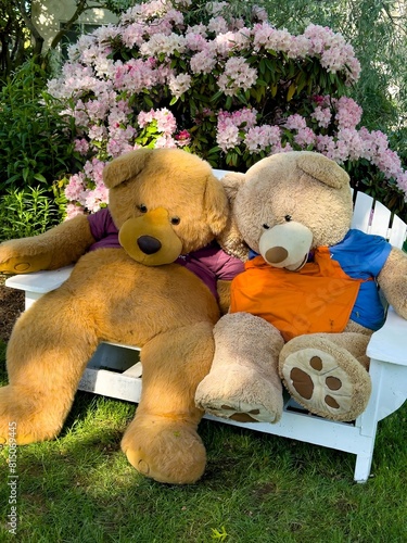 Salem,  Oregon - May 12, 2024:  Two huge teddy bears seated on a garden bench