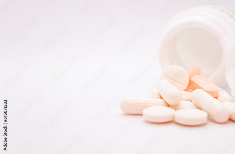 Pills spilling out of pill bottle on white background with copy space Pills spilling out of pill bottle on white background with copy space