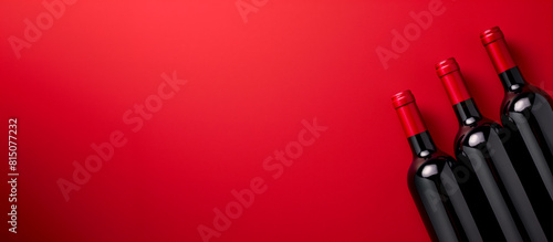 Three bottles of wine on a red background with copy space