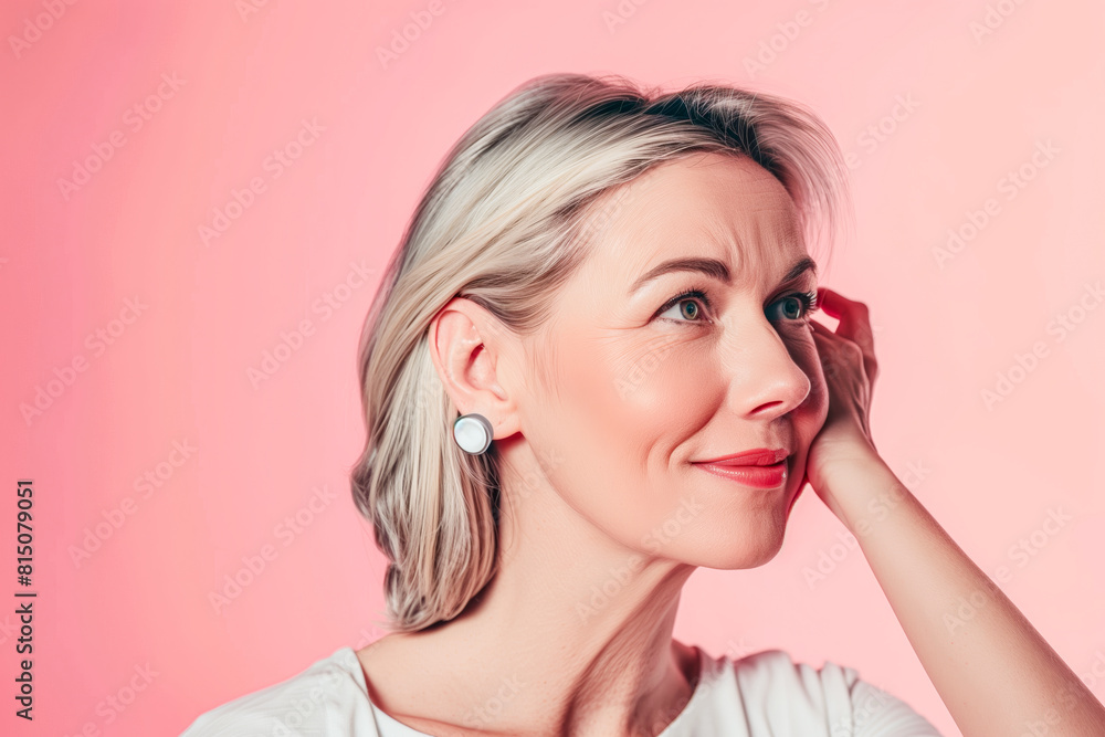 Blond woman wearing earrings on pink background Blond woman wearing earrings on pink background