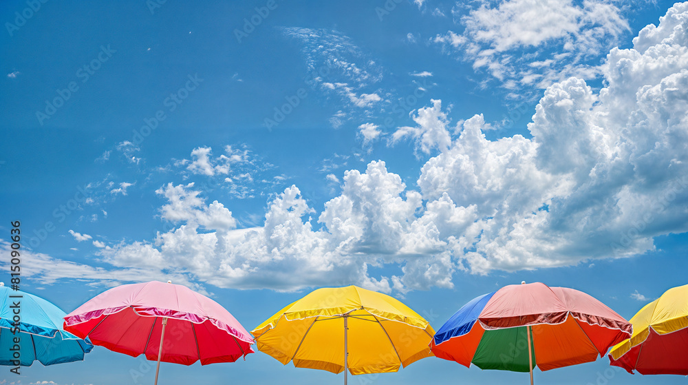 A row of colorful umbrellas are open on a sunny day