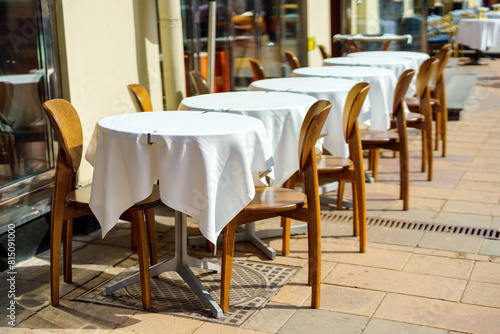 Row of square tables with white tablecloths at an outdoor restaurant © Tatiana