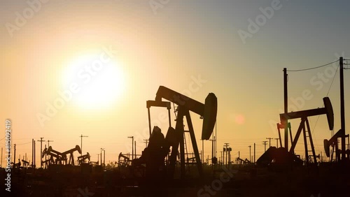 The sun rises behind oil pumps in California