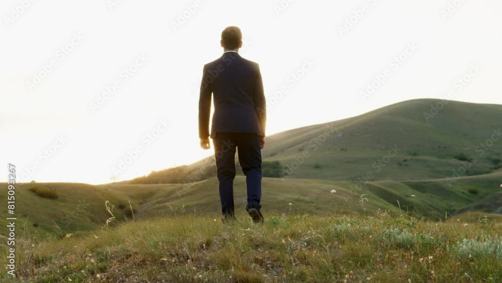 A man in a black business suit has a glow around his silhouette. A man with a tired gait stops and falls to his knees. A man looks at the horizon, where the sun is hidden. A man in a black business suit has a glow around his silhouette. A man with a tired gait stops and falls to his knees. A man looks at the horizon, where the sun is hidden.