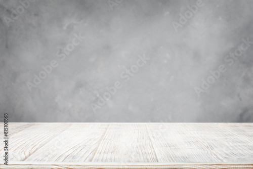 White wooden table with gray concrete wall background