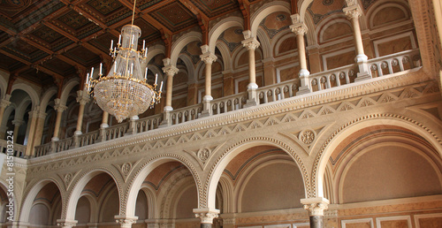 Solemnity hall with carved columns and luxurious crystal chandeliers above the balustrade
