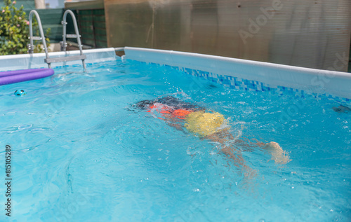 Young swimmer in action  mastering the backstroke in a residential pool  with a focus on form and rhythm