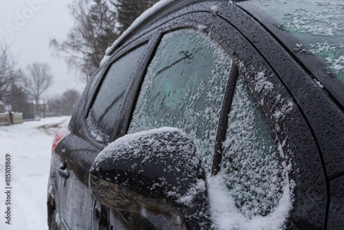 fresh snow covers the surroundings and the car mirror, snow texture on a metal surface, winter