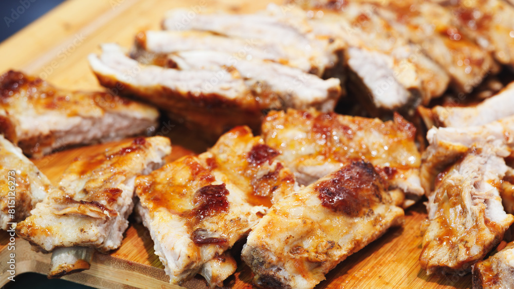 A close up of a piece of meat with a knife on a wooden cutting board. The meat is cut into small pieces and he is raw A close up of a piece of meat with a knife on a wooden cutting board. The meat is cut into small pieces and he is raw
