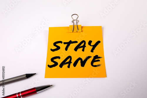Stay Sane Concept. A yellow notepad on a white office table photo