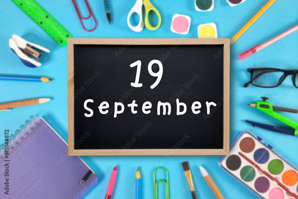 September 19 written in chalk on black board. Calendar date 19th of September on chalkboard on blue blurred school stationery background. Back to school. School event schedule date. Month of autumn. September 19 written in chalk on black board. Calendar date 19th of September on chalkboard on blue blurred school stationery background. Back to school. School event schedule date. Month of autumn.