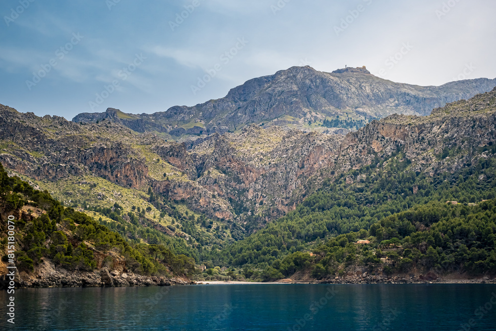 Cala Tuent bay in Mallorca, showcasing the majestic Serra de Tramuntana mountains crowned by the prominent Puig Major peak with its distinctive dome, a perfect retreat for vacations amid nature beauty Cala Tuent bay in Mallorca, showcasing the majestic Serra de Tramuntana mountains crowned by the prominent Puig Major peak with its distinctive dome, a perfect retreat for vacations amid nature beauty