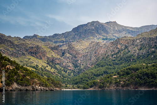 Cala Tuent bay in Mallorca  showcasing the majestic Serra de Tramuntana mountains crowned by the prominent Puig Major peak with its distinctive dome  a perfect retreat for vacations amid nature beauty