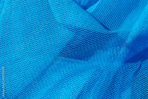 Close up of sun shade net with mesh lay on the ground with sunlight, Blue debris netting is the product mostly used for scaffolding work in construction site, Abstract fabric pattern background. photo