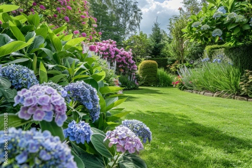 A lush  well-maintained garden with hydrangeas and sage plants in the foreground  surrounded by green grass under bright sunlight Generative AI