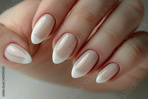 A beautiful woman holds her hands up to the camera showing her well-groomed fingers with white nail polish