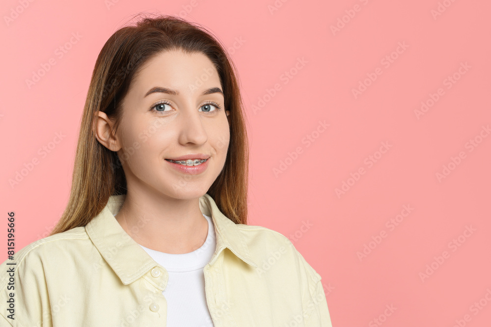 Portrait of smiling woman with dental braces on pink background. Space for text Portrait of smiling woman with dental braces on pink background. Space for text