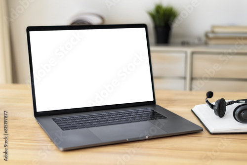 Open laptop with blank screen on table in home office, mockup, template for your text