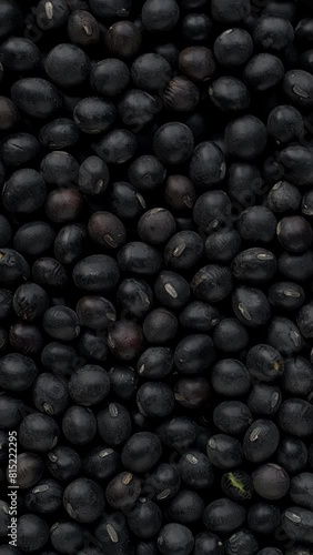 Macro view of black soybean as an abstract food pattern. Uncooked beans are dry roasted to destroy trypsin inhibitors. Spinning around the left bottom corner. Vertical video; photo