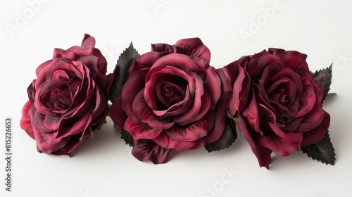 Three deep crimson roses set against a stark white backdrop