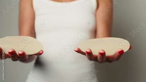 Medical Decision: Woman Holds Removed Breast Implants After Surgery photo