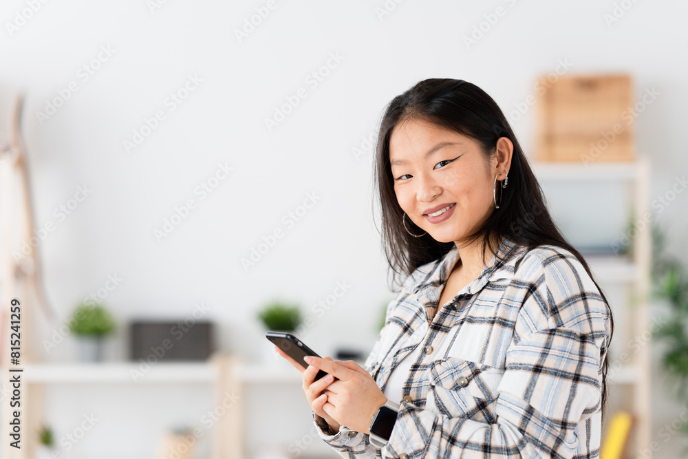 Horizontal photo of a beauty asian smiling woman using phone at home Horizontal photo of a beauty asian smiling woman using phone at home