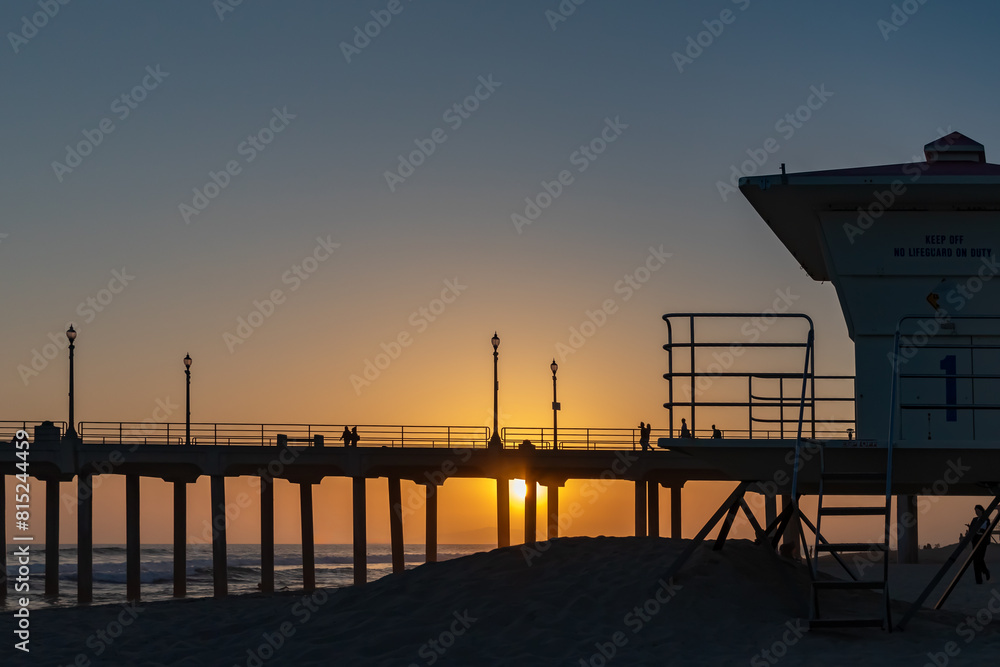 Huntington Beach at Sunset with Lifeguard Tower in Foreground and Pier in Background, California, USA-distant people, horizontal Huntington Beach at Sunset with Lifeguard Tower in Foreground and Pier in Background, California, USA-distant people, horizontal