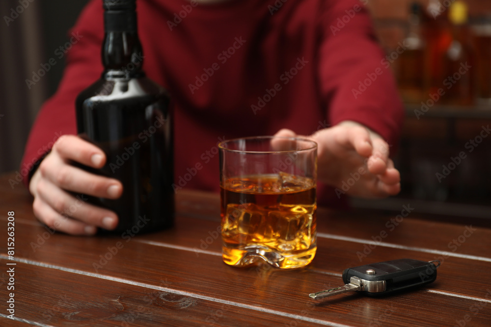 Man reaching for alcoholic drink at table with car keys, closeup. Don't drink and drive concept Man reaching for alcoholic drink at table with car keys, closeup. Don't drink and drive concept