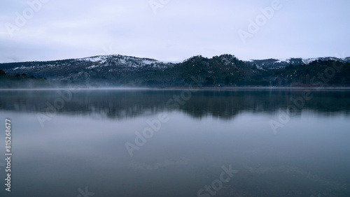 Long exposure view of the serene lake  forest and mountains at sunrise. Beautiful landscape reflection in the water surface. 