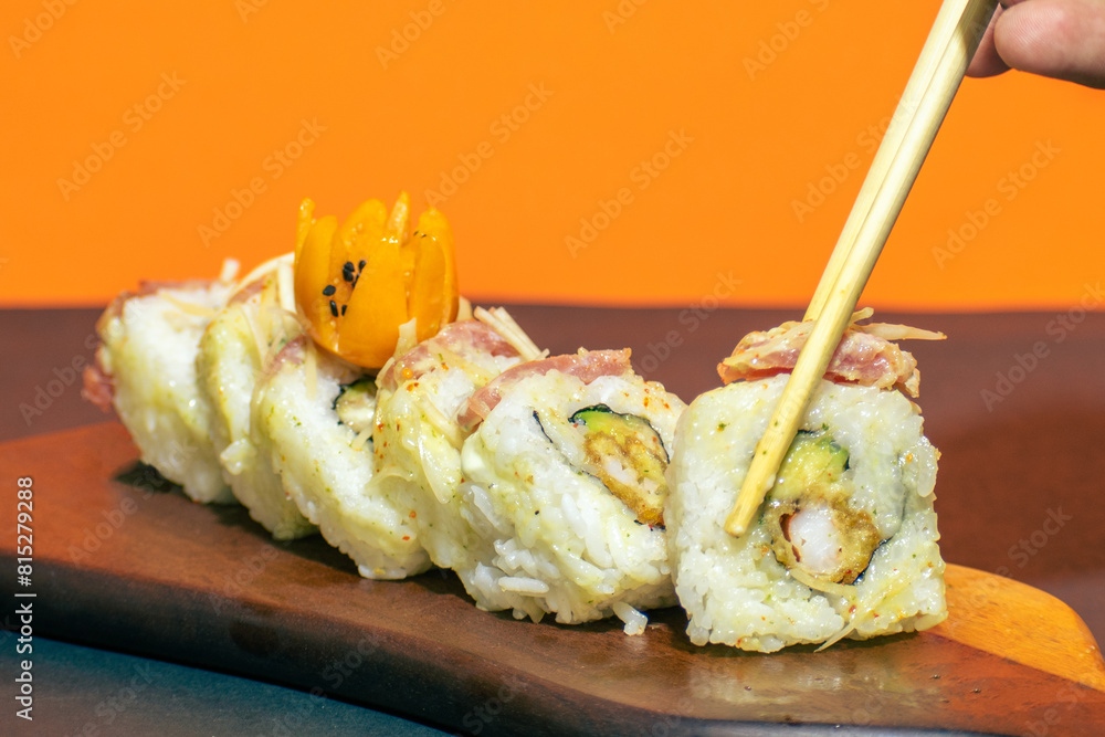Maki rolls about to be eaten with chopsticks, a delicious meal. Maki rolls about to be eaten with chopsticks, a delicious meal.
